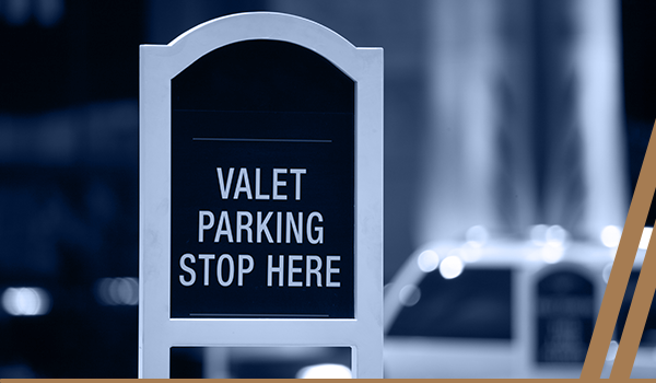 there is a stand with a sign that reads "Valet Parking, stop here."