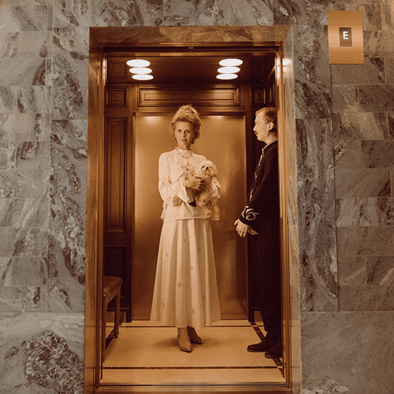 a man and woman standing in an elevator.