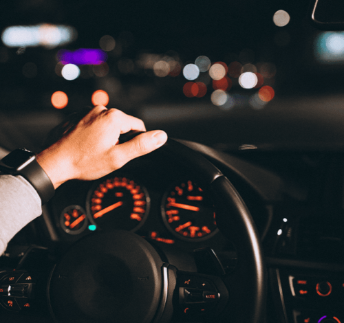 A man providing driver services in Houston, driving a car at night.