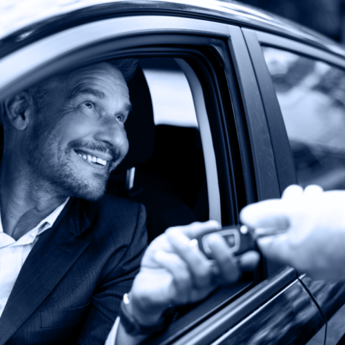 A professional valet hands over car keys to a smiling customer in Bellaire, offering seamless valet services with a courteous touch.