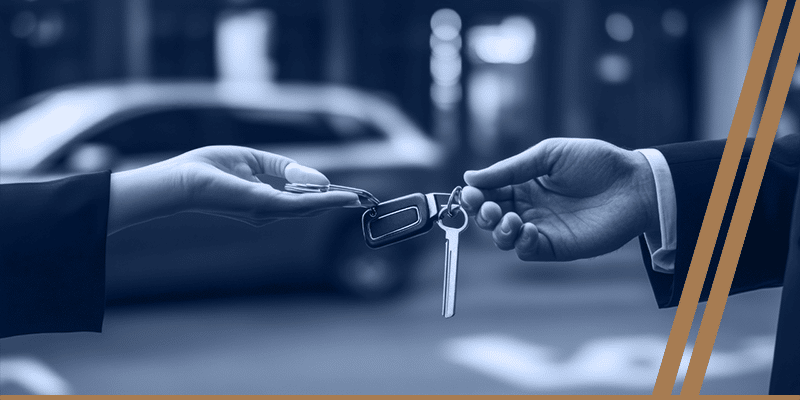 Two hands exchange keys, with blurred cars in the background, capturing the essence of a seamless valet service in Bellaire.